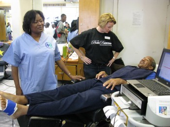 UNAC/UHCP Member Darla Tillman, RN, administers a peripheral arterial disease screening exam to Crenshaw community members to locate any early warning signs for serious medical conditions.